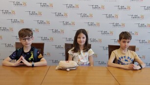 Troje dzieci siedzących przy stole
